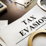 Tax Evasion Papers with handcuffs