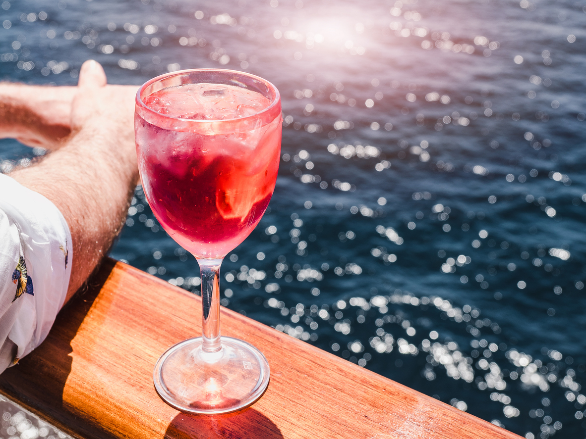 Pink cocktail on the edge of a boat rail